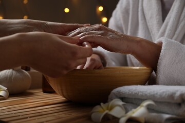 Woman receiving hand treatment at table in spa, closeup
