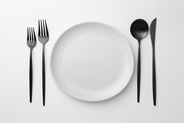 Empty plate, forks, spoon and knife on white background, flat lay
