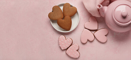 Teapot with tasty heart shaped cookies on pink grunge background with space for text. Valentine's...