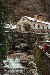 Old bridge, river and rocky house