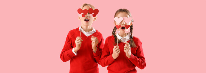 Funny little children with paper hearts on pink background. Valentine's day celebration