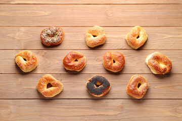 Tasty bagels with sesame and poppy seeds on wooden background