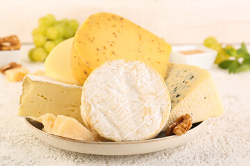 Plate with different types of cheese on table