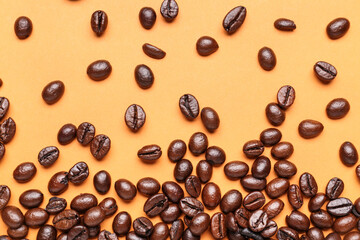 Scattered coffee beans on orange background