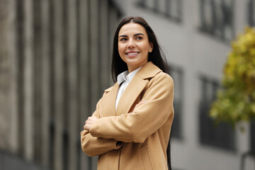 Smiling woman with crossed arms outdoors. Lawyer, businesswoman, accountant or manager