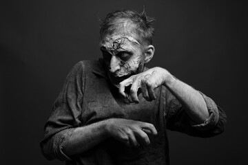 Scary zombie on dark background, black and white effect. Halloween monster