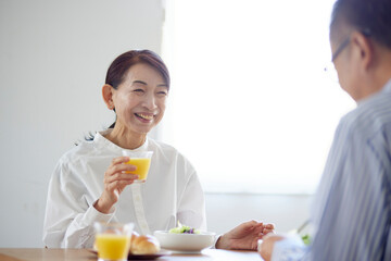 Obraz na płótnie Canvas リビングで朝食を食べる日本人のシニア夫婦