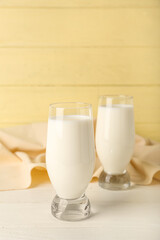 Glasses of fresh milk on table