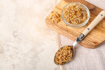 Bowl and spoon with sprouted wheat on grunge table