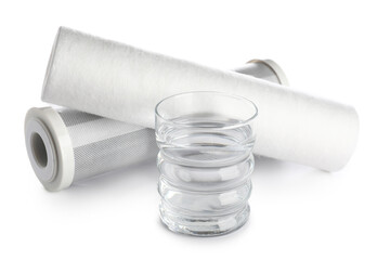 Glass of liquid and water filter cartridges isolated on white background