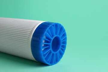 New water filter cartridge on green background, closeup