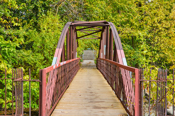 Rustic Metal Truss Bridge in Lush Park with Autumn Foliage, Eye-Level View