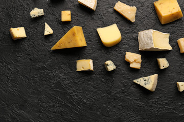 Pieces of tasty cheese on dark background