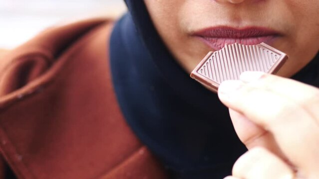 Closeup of woman eating chocolate candy ,
