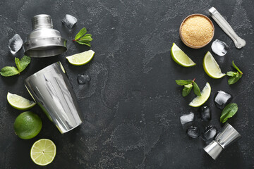 Frame made of shaker, measure cup and ingredients for preparing mojito on dark background