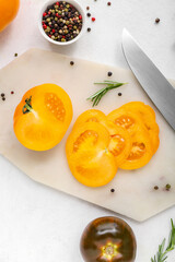 Board with fresh tomatoes and peppercorn on white background