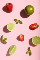 Fresh strawberries with lime and mint on pink background