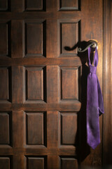 Corbata morada sobre manija/picaporte de puerta de madera (1)