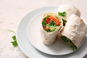 Plates of tasty lavash rolls with tomatoes and greens on light background
