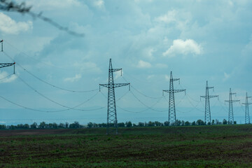 High voltage towers with sky background. Power line support with wires for electricity transmission. High voltage grid tower with wire cable at distribution station. Energy industry, energy saving