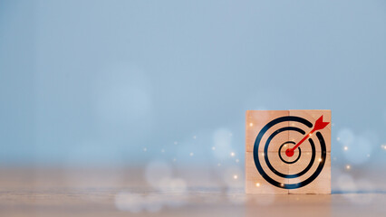 Business goal and success concept. Focus on a goal and achieve a successful business. Initiation for planning to reach the target. Darts target aim icon on wooden cubes with Copy space. - obrazy, fototapety, plakaty