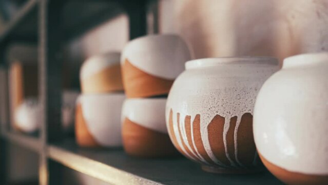 Pottery, creativity and ceramics on shelf in a store, workshop or studio for manufacturing display. Art, handicraft and closeup of handmade clay design products for craft or creation in a shop.