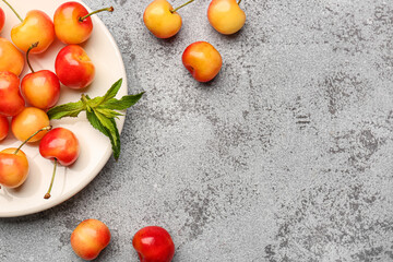 Tray with sweet yellow cherries and mint on grey background