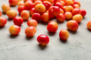 Many sweet yellow cherries on grey background