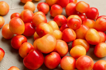 Many sweet yellow cherries on grey background, closeup