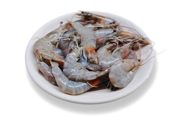 Fresh shrimp tails isolated. Raw headless prawn, pacific shrimp, uncooked tiger prawns, jumbo seafood on white plate on isolated background 