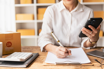  SME Startup, small business, female entrepreneur, working, unpacking, checking orders online To prepare to pack boxes to sell to customers with online business ideas from afar.