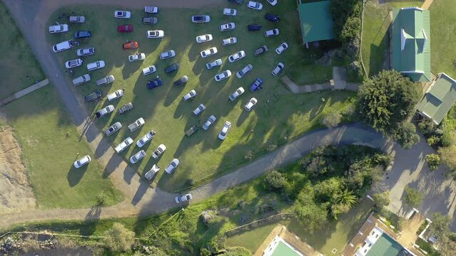 Drone, cars at outdoor cinema and nature with pathway or road, buildings and green landscape. Parking lot, transportation with film entertainment in countryside and aerial view of trees with vehicles