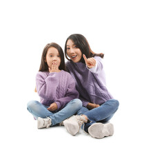 Asian mother with her little daughter sitting on white background