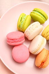 Fototapeta premium Plate with sweet macaroons on pink background, closeup