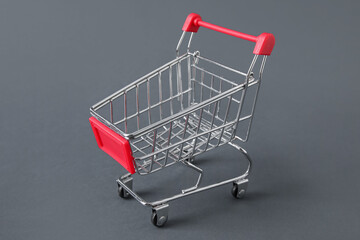 Shopping cart on grey background, closeup