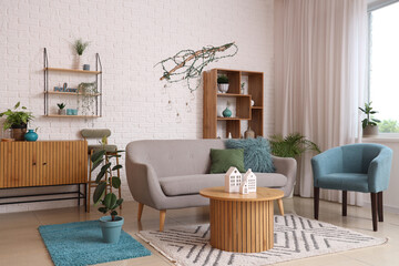 Interior of modern living room with comfortable armchair, sofa and table