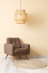 Stylish brown armchair and wicker lamp near beige wall