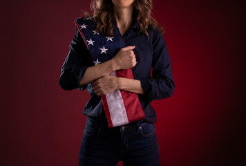 A woman holding an American flag across her chest