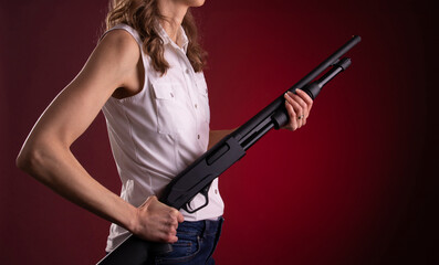 A woman holding a shotgun for self defense