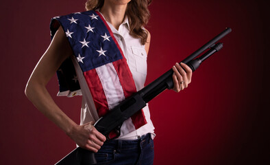 Armed citizen holding a shotgun with an American flag over her shoulder