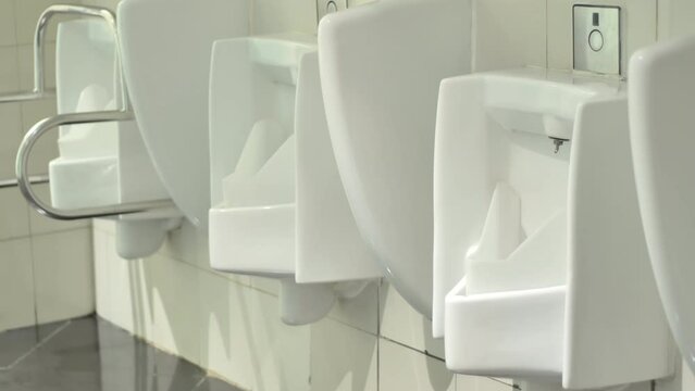 Clean urinal toilets in a modern building with indoor lighting