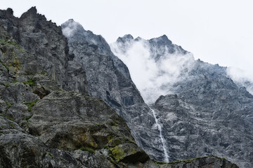 Fototapeta na wymiar Solid mountain slope with the Midagrabin waterfall