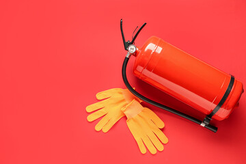 Fire extinguisher and gloves on red background