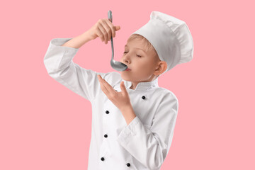 Cute little chef with ladle on pink background. Opposite Day celebration