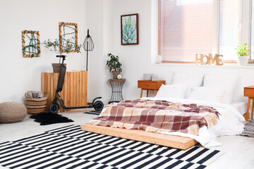 Interior of bedroom with electric scooter and bed