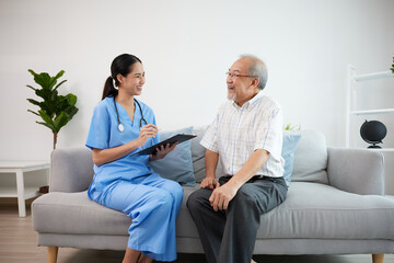 nurse or caregiver holding a clipboard meeting and talking about health with elderly man