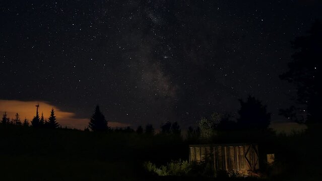 Milkway in valey forest windturbine and light on small shack