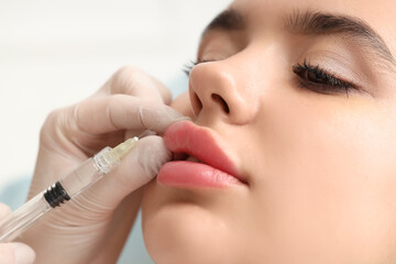 Young woman receiving lip injection in beauty salon, closeup