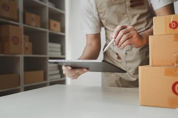 tablet are being used to do various activities to promote sales to stores, owner of an online store packs products into parcel boxes based on orders from online sales sites.