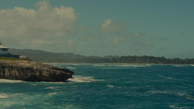 the beautiful blue Pacific ocean with soothing waves against a rocky peninsula and the shoreline in Honolulu, Hawaii